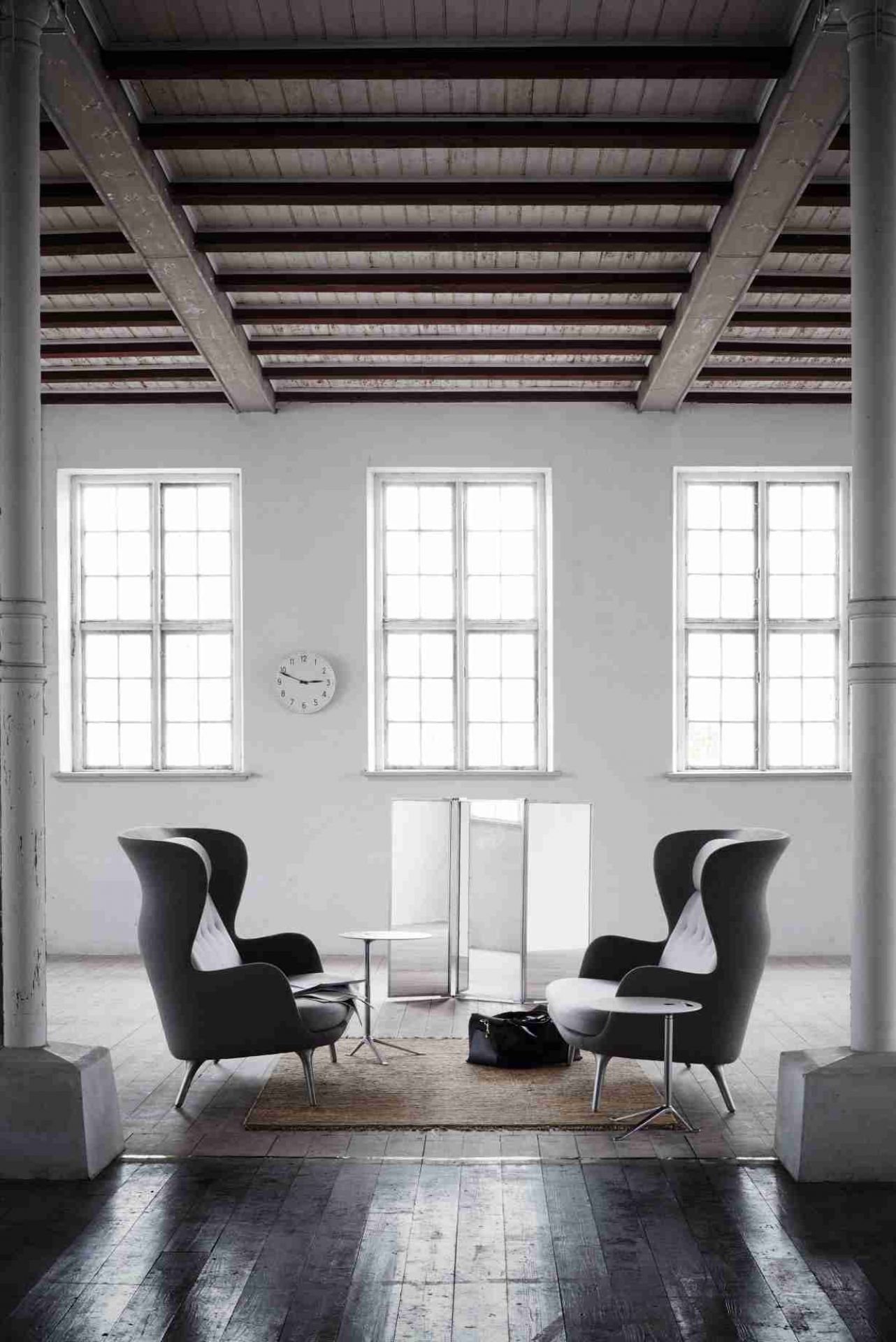 Zwei Fritz Hansen Ro Sessel in grau mit Beistelltischen in einem hellen, modernen Loft.