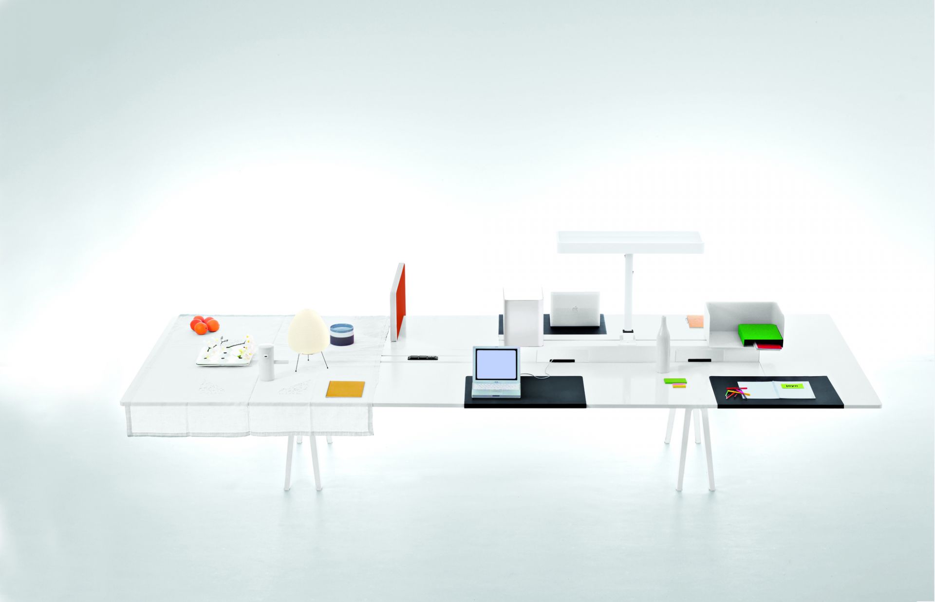 Vitra Joyn Schreibtischunterlage: Großzügiger, weißer Bürotisch mit zwei Laptops, Lampe und Büro-Accessoires für modernes Arbeiten.