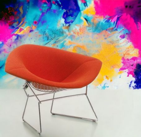 Oranger Diamond Sessel von Knoll International mit Drahtgestell vor buntem Hintergrund. Designklassiker.