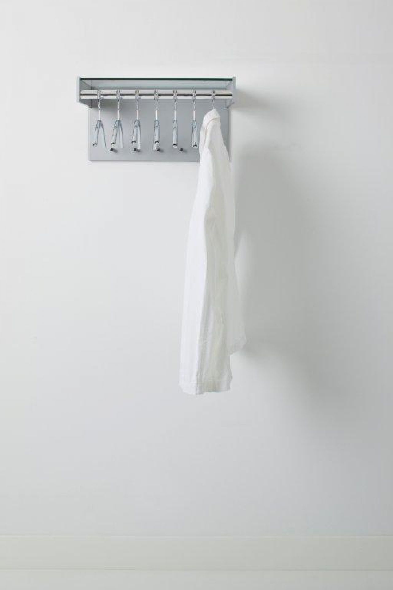 Hangon Wandgarderobe mit zwölf Haken und weißem Hemd an der Wand.