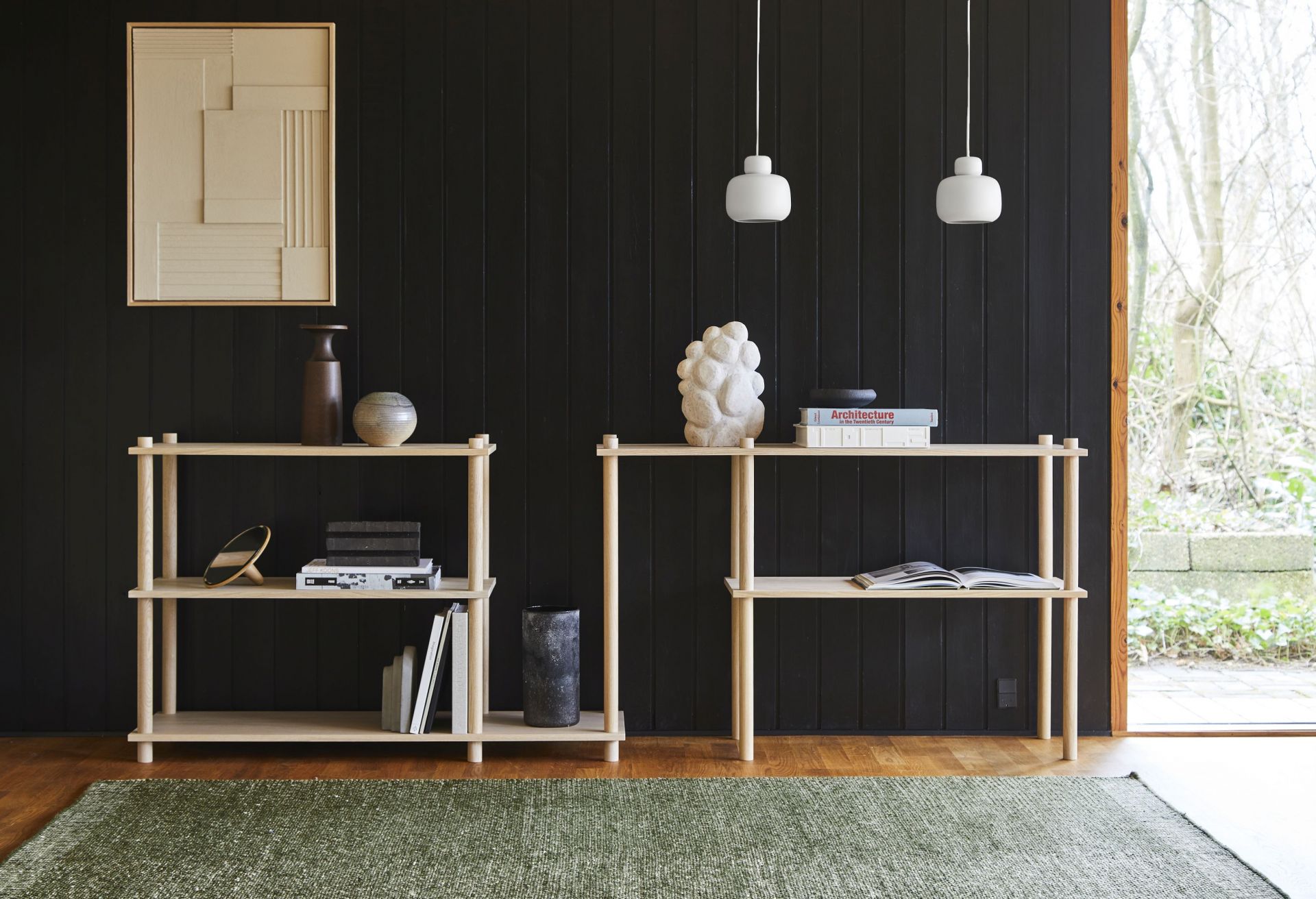 Zwei weiße Stone Pendant Pendelleuchten von Woud hängen über Holzregalen in einem stilvollen Interieur.