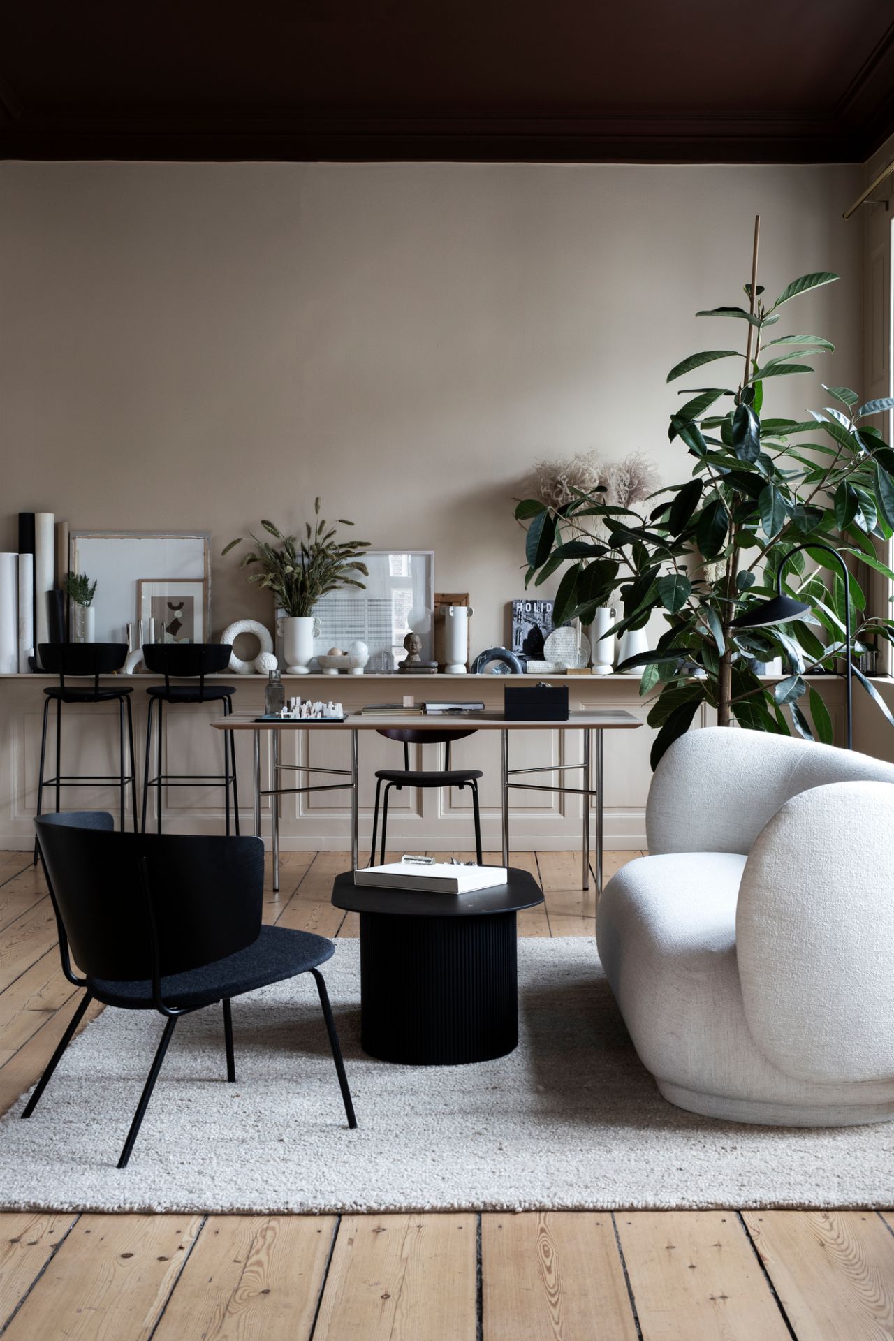 Weißer Rico Lounge Chair Sessel von Ferm Living in stilvollem Wohnzimmer mit Teppich.