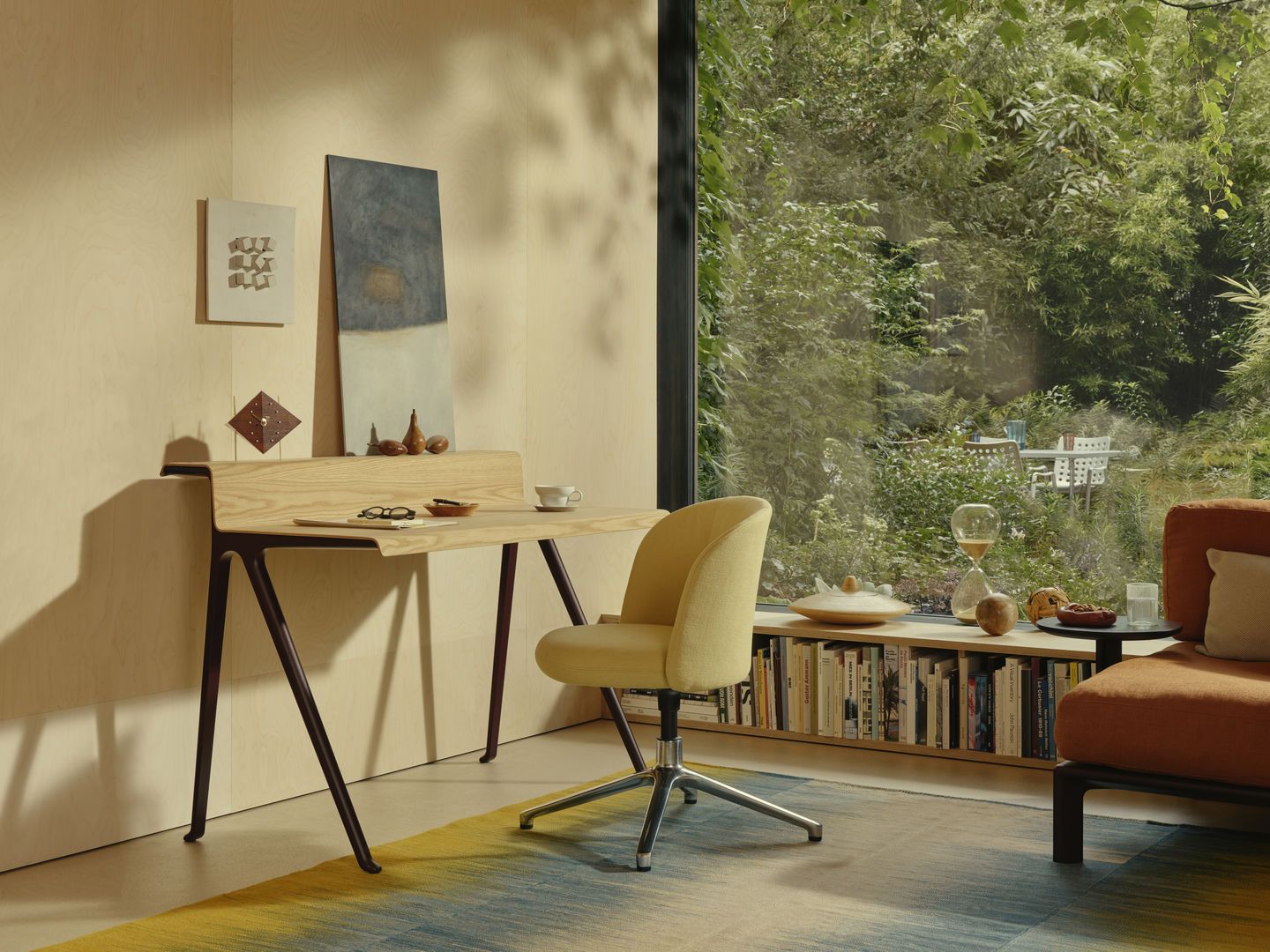 Vitra Schreibtisch Courier aus hellem Holz mit dunklem Gestell in modernem Arbeitszimmer.