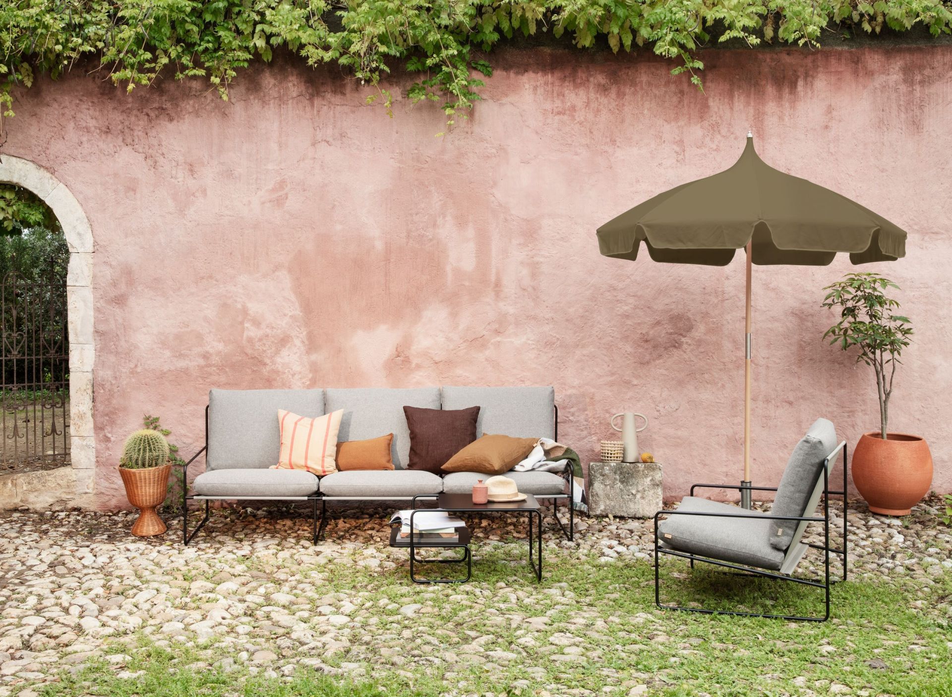 Desert 1-Sitzer Outdoor Sessel von Ferm Living mit schwarzem Gestell im Garten. Bequemer Loungesessel.
