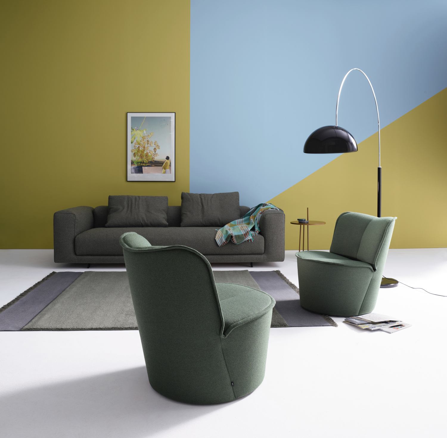 Nenou Sessel von Cor in Grün, Teil einer modernen Wohnzimmer-Szene mit Sofa.