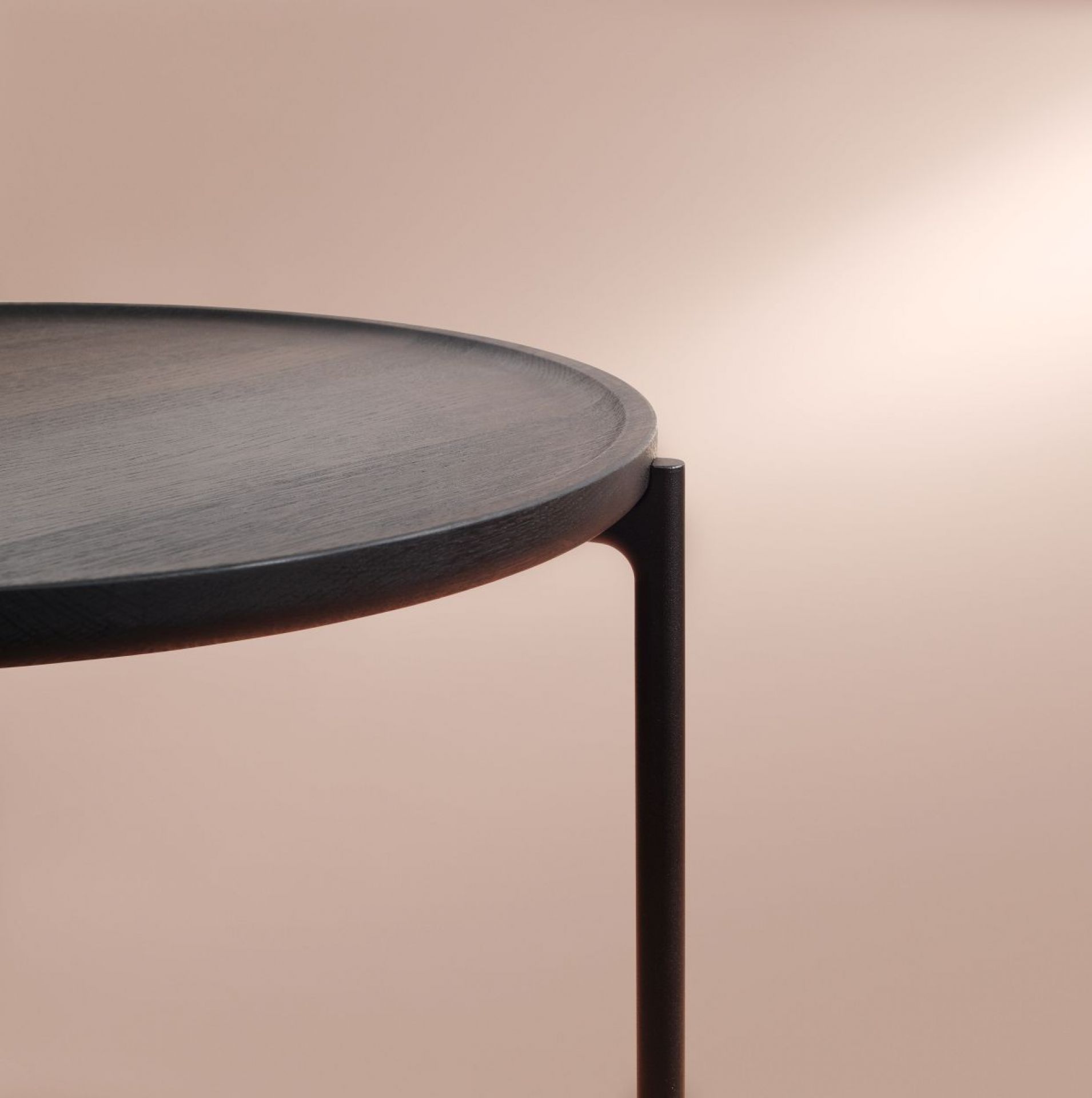 Detailaufnahme Savoye Tisch von Eva Solo: runder Couchtisch aus geräucherter Eiche mit schwarzem Metallfuß.