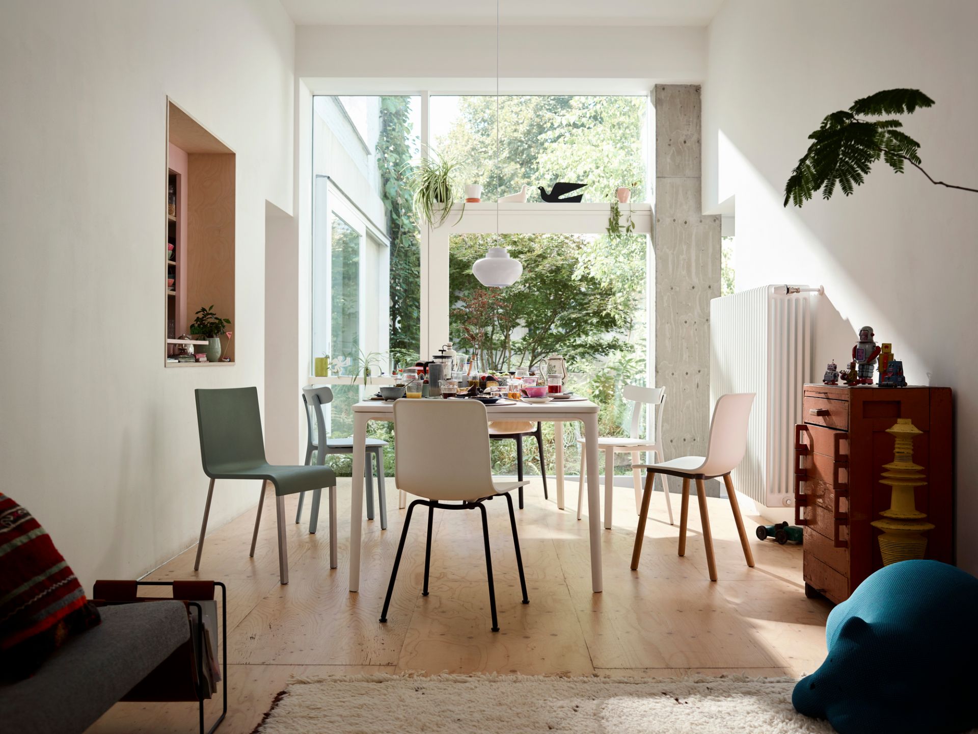 Esszimmer mit Esstisch und verschiedenen Hal Ply Wood Stühlen von Vitra in modernem Ambiente.