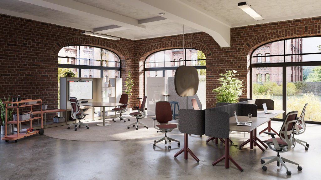Moderner Büroraum mit Steelcase Karman Bürodrehstühlen in Rot und Grau für ergonomisches Sitzen.