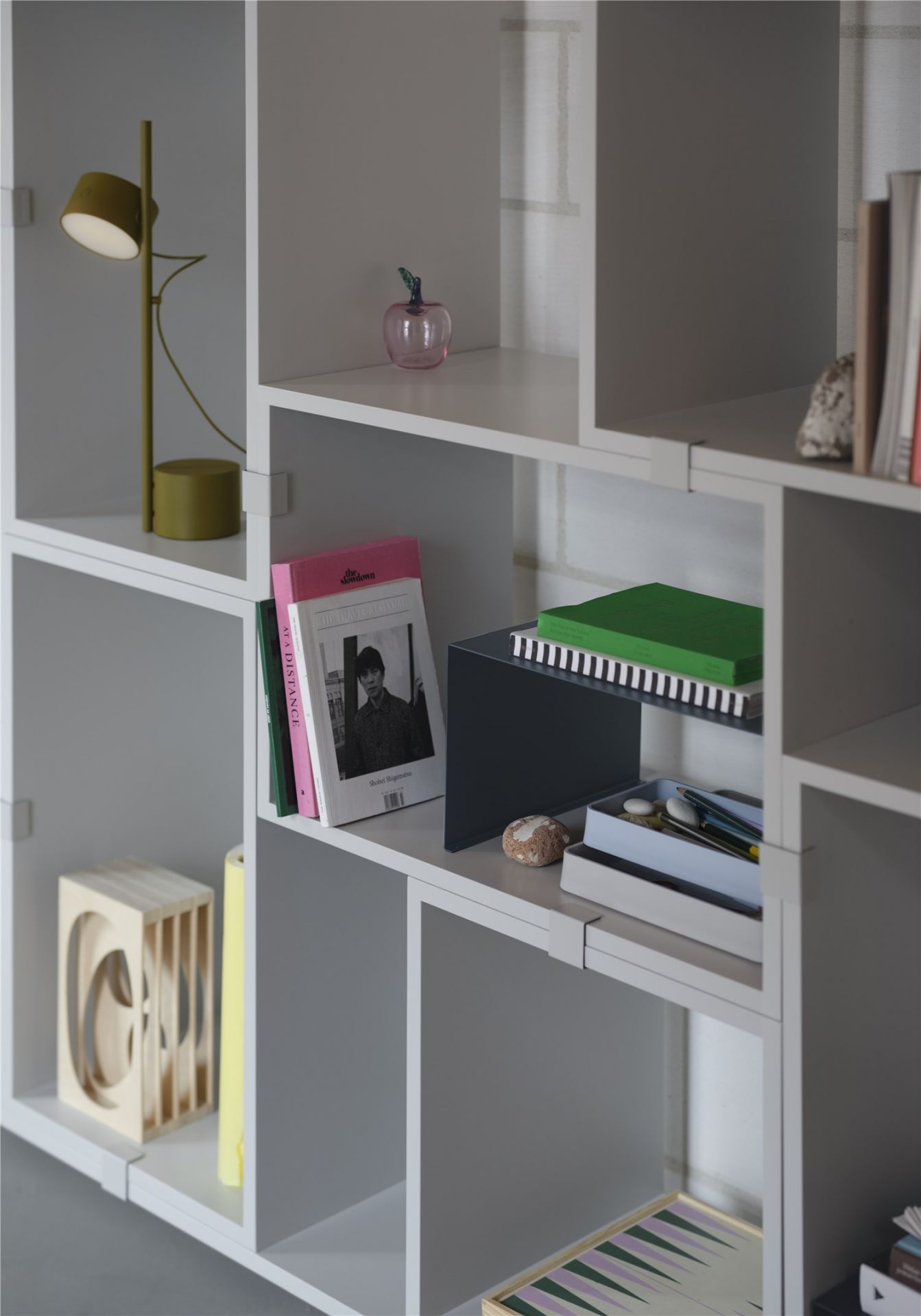 Nahaufnahme der Muuto Post Table Lamp Tischleuchte in Braun-Grün auf einem Regal.