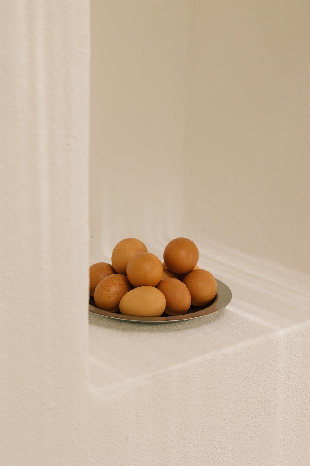 Nahaufnahme von braunen Eiern auf einem silbernen Tumbled Plate Teller von Ferm Living, ideal für Picknick und Camping.