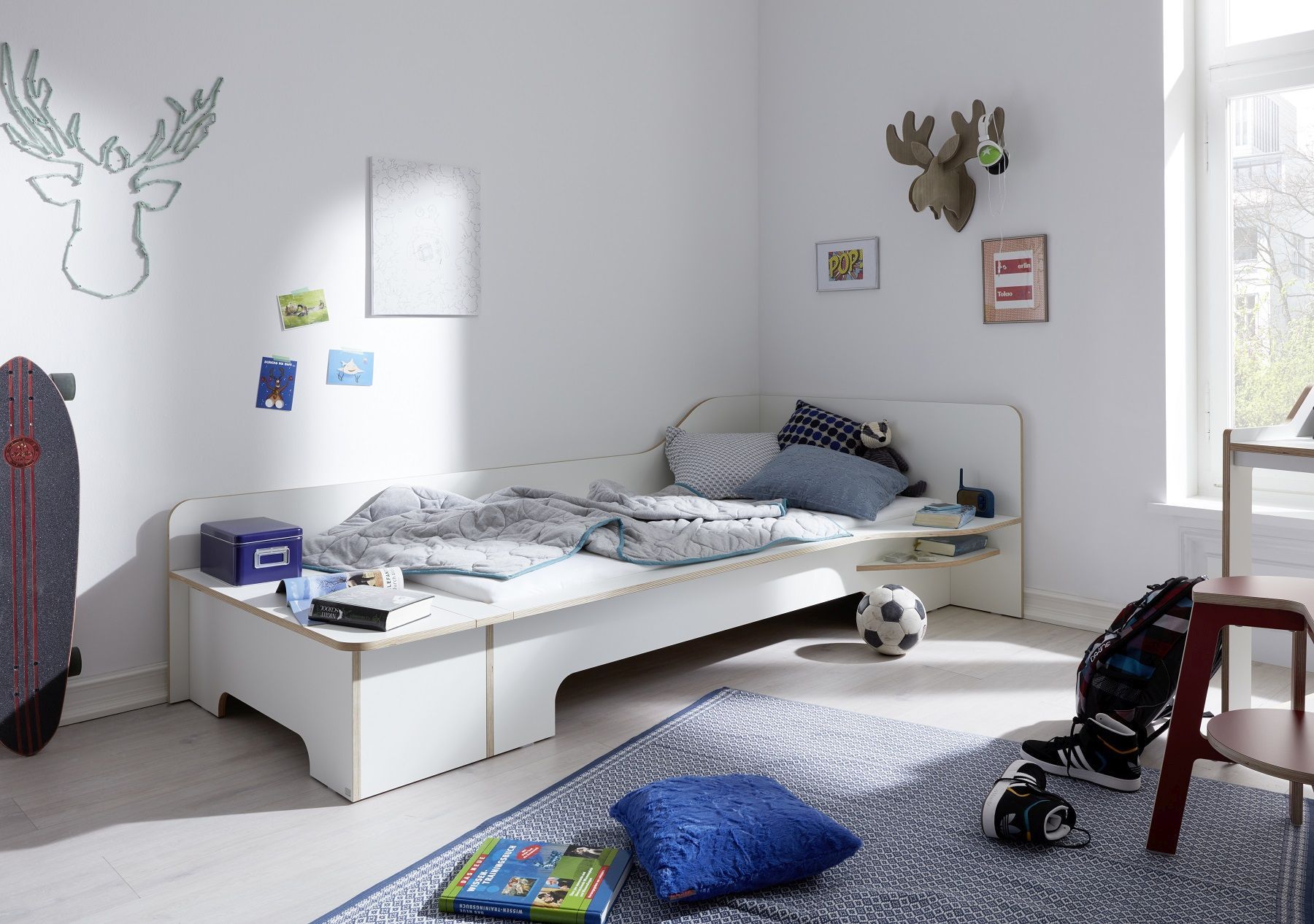 Modernes Jungenzimmer mit weißem Plane Einzelbett von Müller Möbelwerkstätten, inklusive Bettwäsche, Teppich und Deko.
