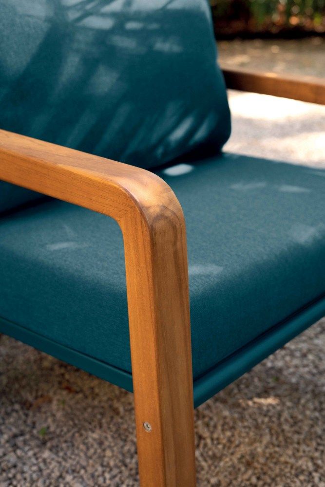 Detailaufnahme des Somerset Outdoor Sessels von Fermob mit blauem Bezug und Holzarmlehne.