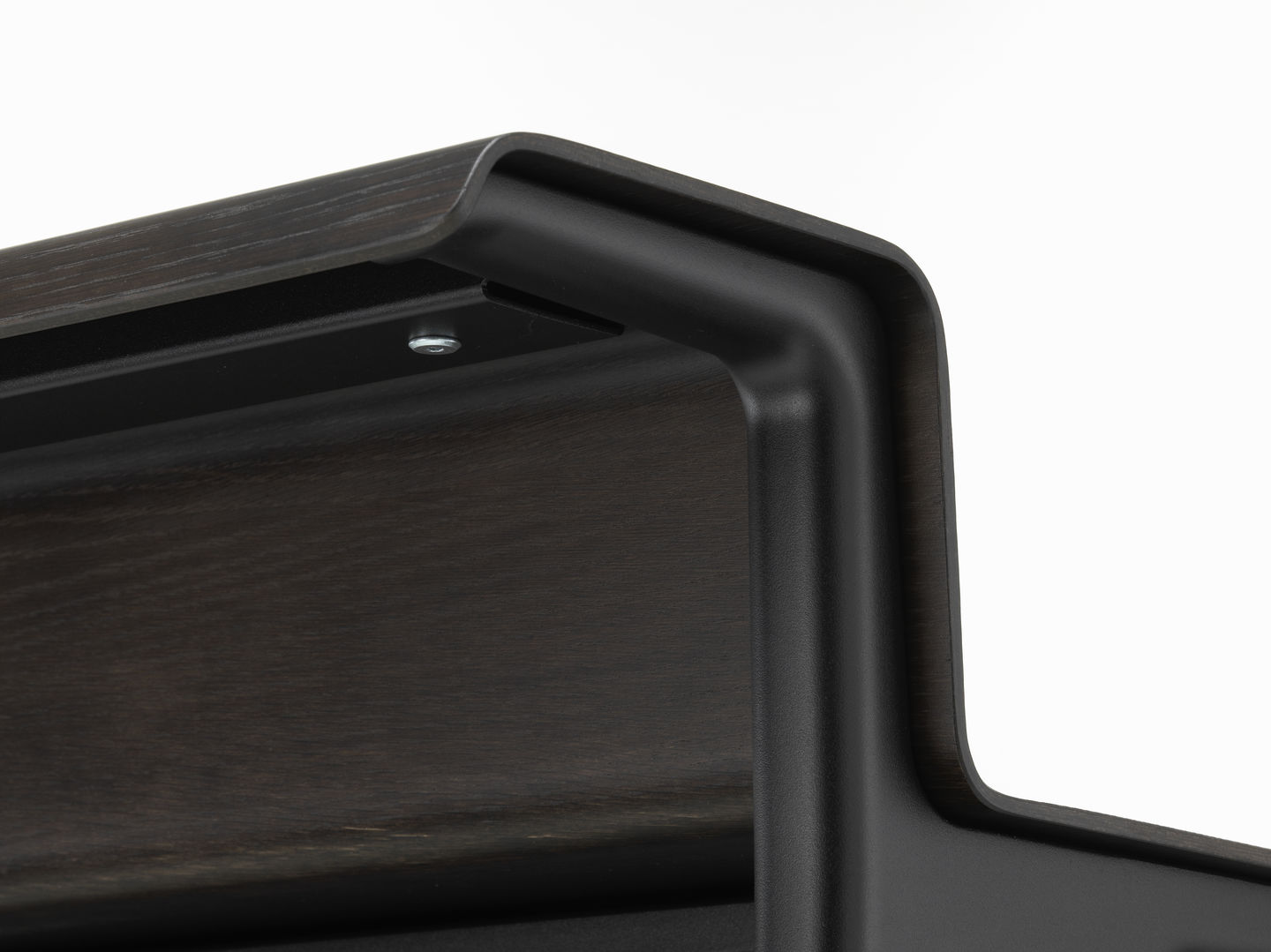 Detailaufnahme der Tischplatte und des Gestells vom Vitra Courier Schreibtisch in dunklem Holz.