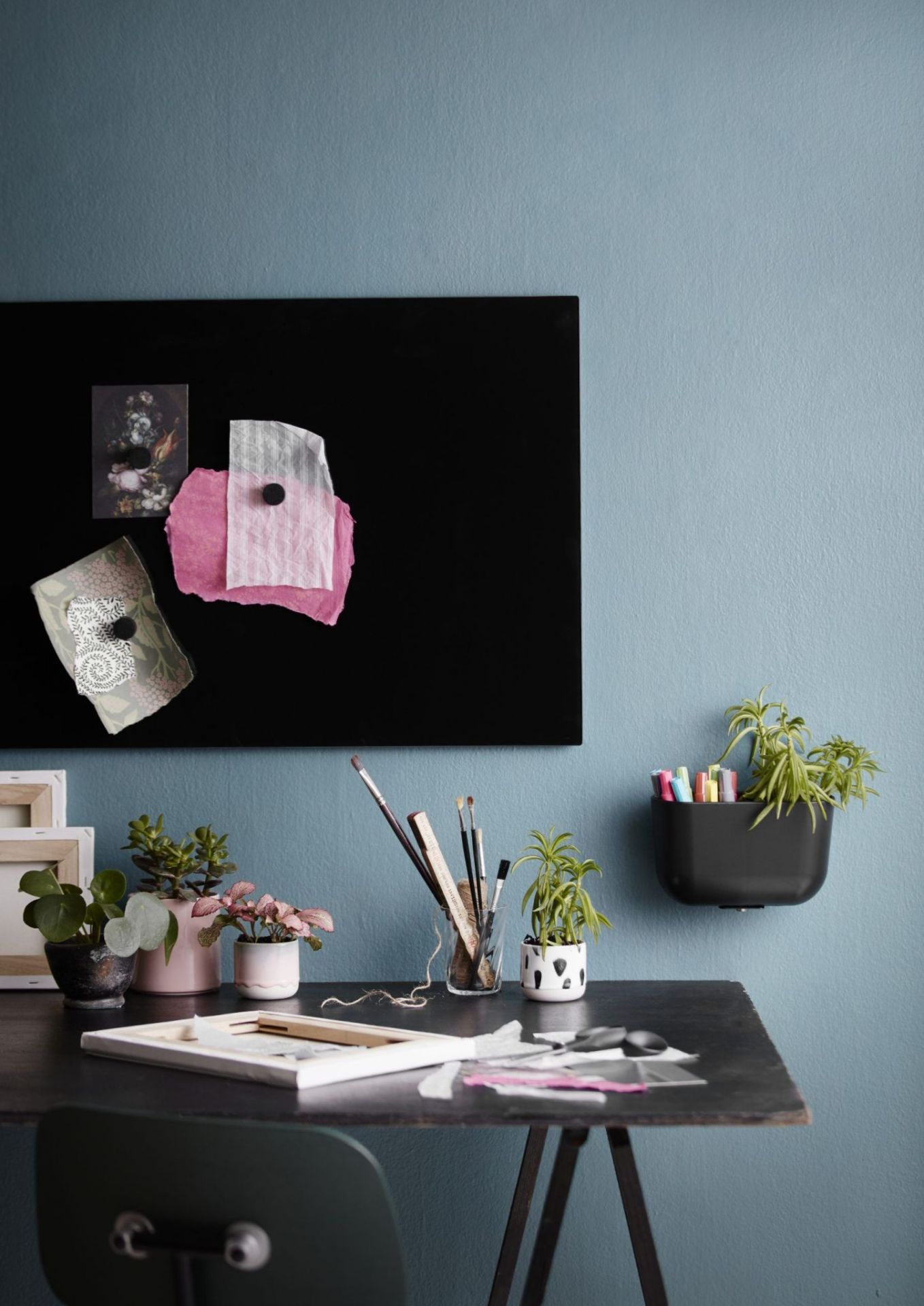 Schwarze Chat Board Glastafel an der Wand mit Magneten und Dekorationen. Magnetische Wandtafel im Büro.