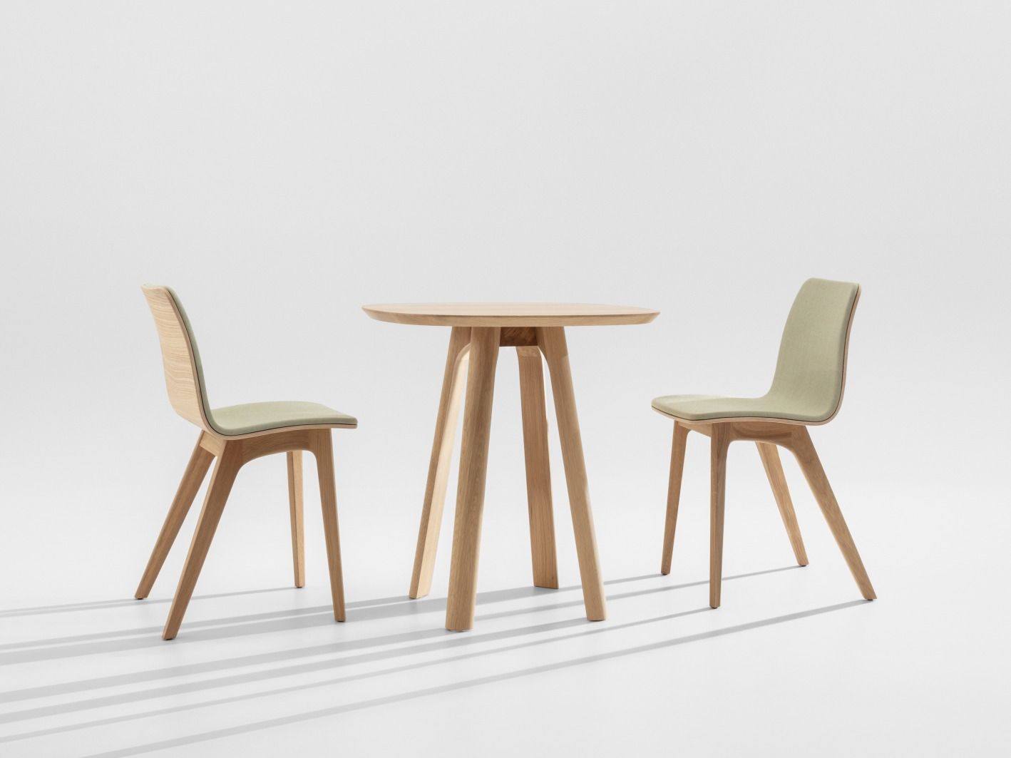 Morph Holzstuhl mit Sitzpolster und passender Holztisch, helles Holz, modernes Design.