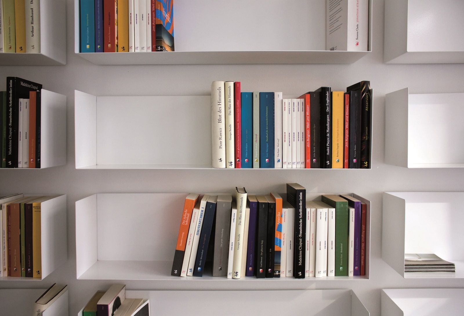 Weiße a Linea1 Regale von Müller Möbelwerkstätten an einer Wand mit Büchern.