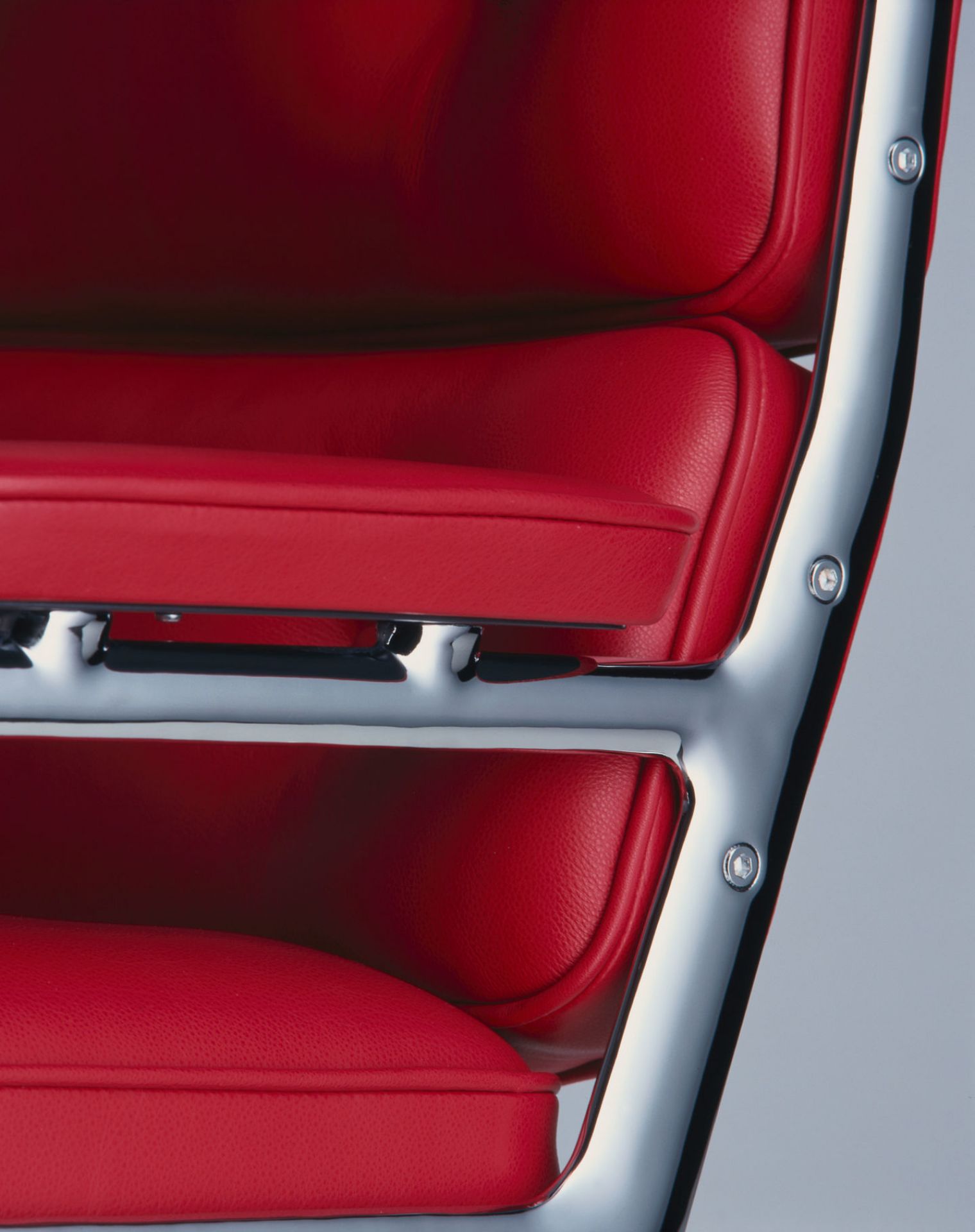 Detailaufnahme: Roter Vitra Lobby Chair ES 105 Stuhl mit verchromtem Gestell. Designklassiker für Büro und Wohnen.