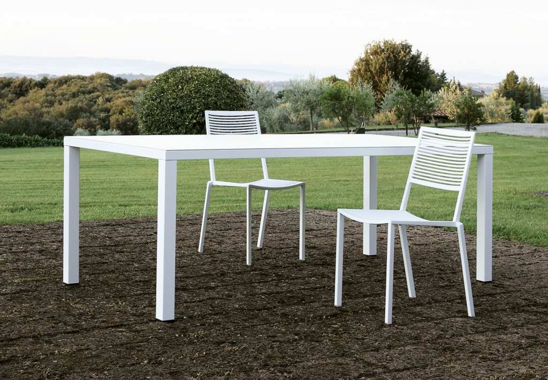 Weißer Easy Outdoor Tisch mit Stühlen auf Rasen, ideal für Garten und Terrasse.