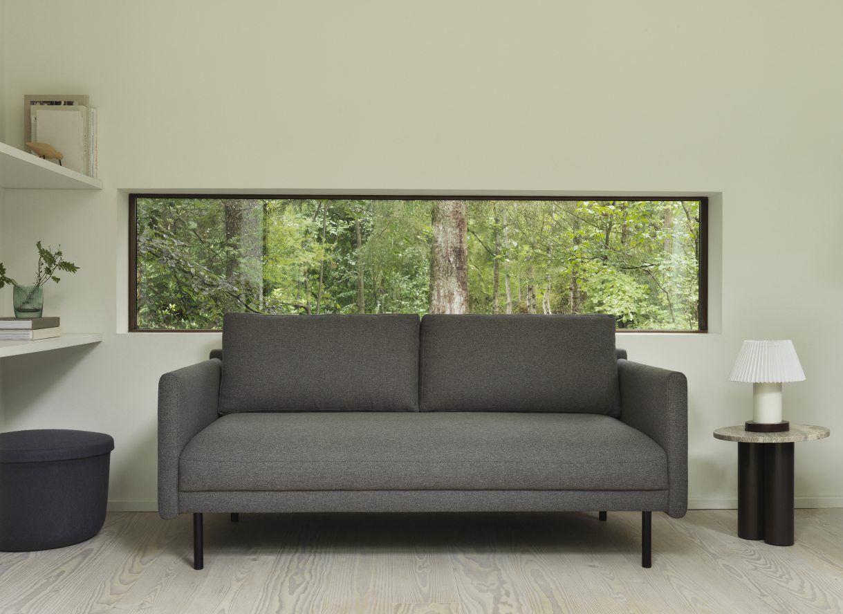 Graues Sofa mit Normann Copenhagen Dit Coffee Table Beistelltisch und Lampe in minimalistischem Wohnzimmer.