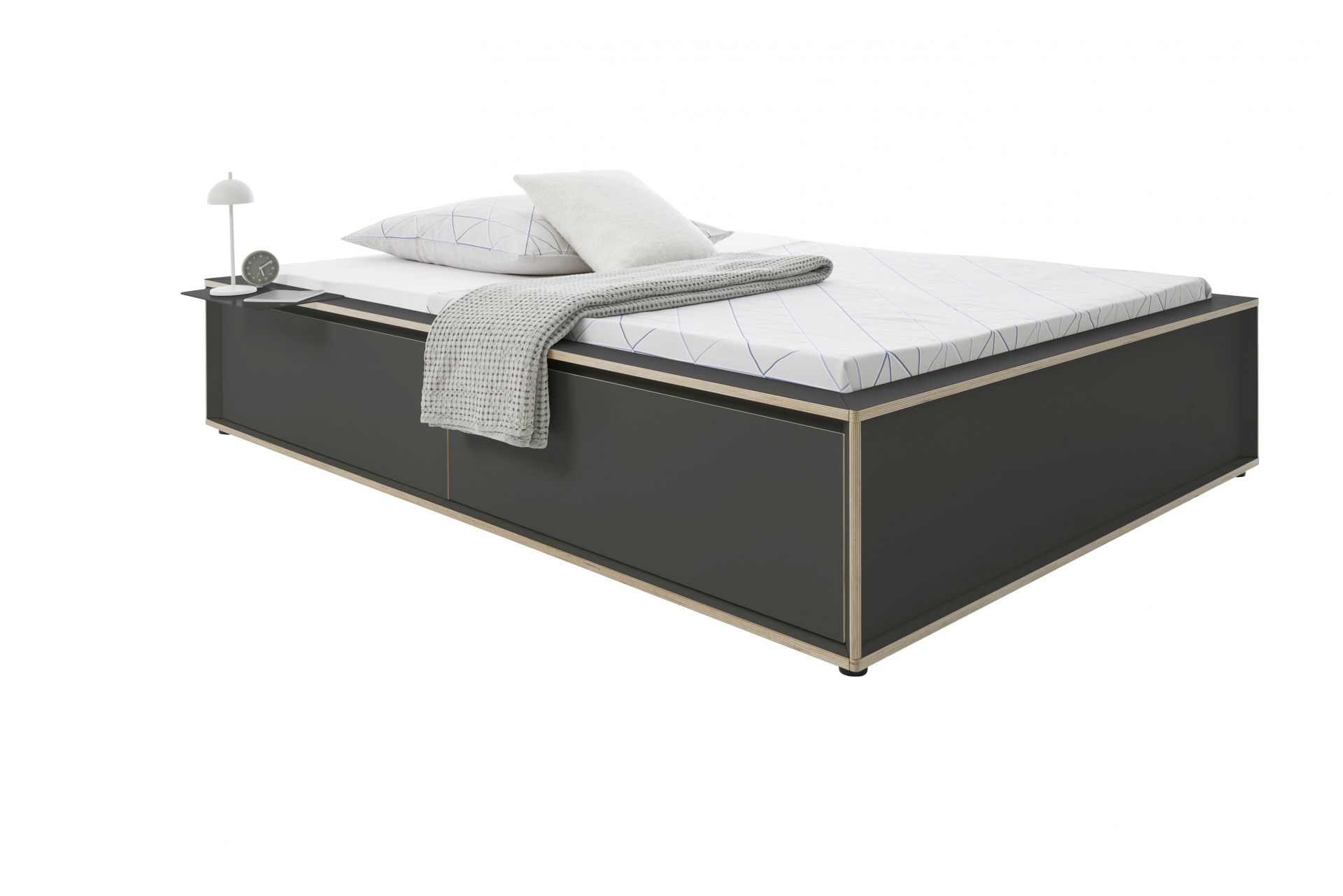 Spaze Bett von Müller Möbelwerkstätten in Anthrazit mit Nachttisch, Kissen und Decke.