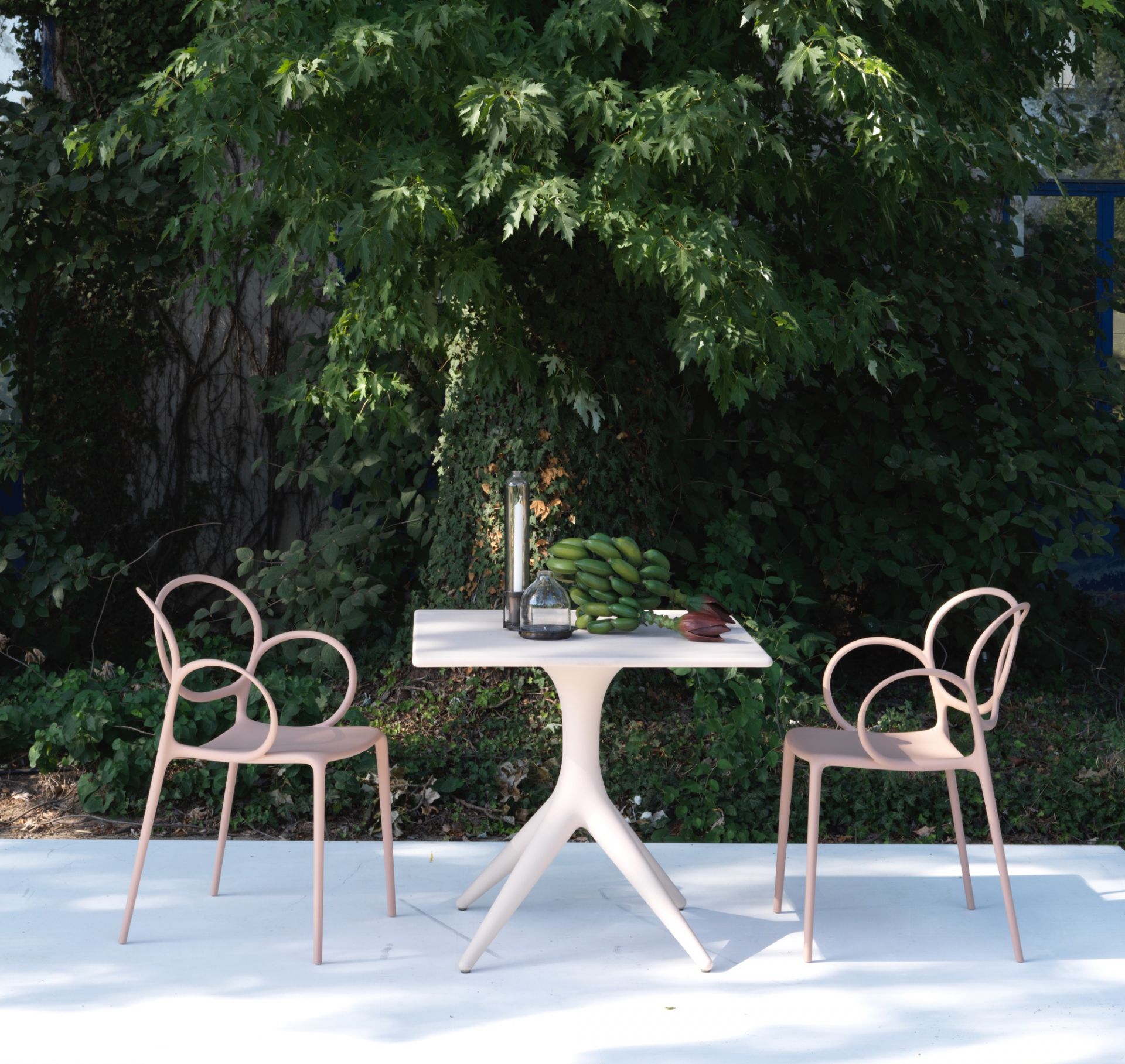 Sissi Armlehnstuhl von Driade im Outdoor-Bereich. Design Gartenstuhl mit Armlehne in Rosa.