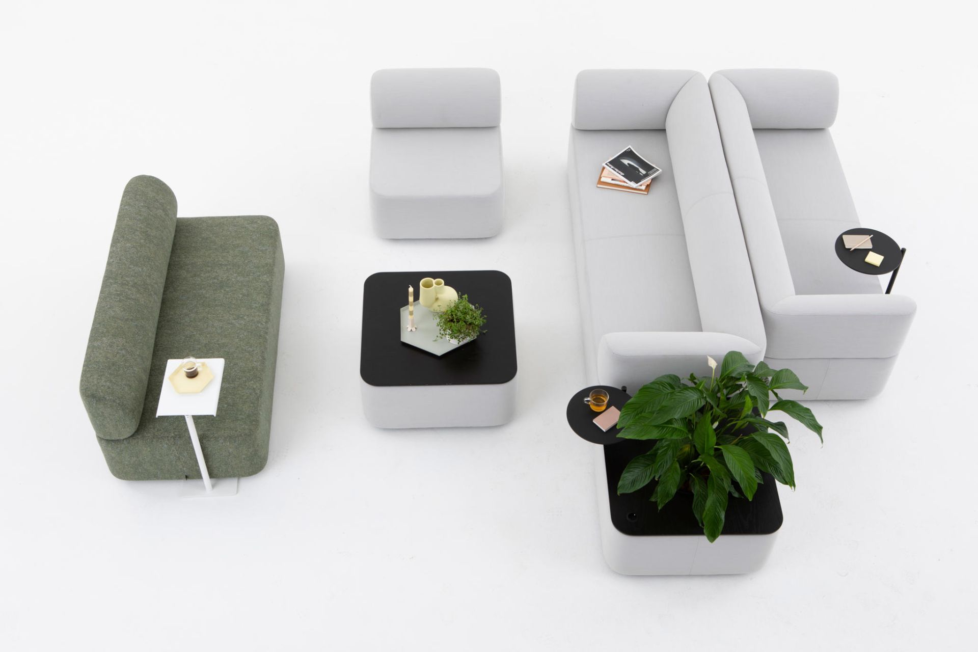 Cascando Mezza Sitzelement Sofa in Grau und Grün mit Beistelltischen und Dekoration, Vogelperspektive.