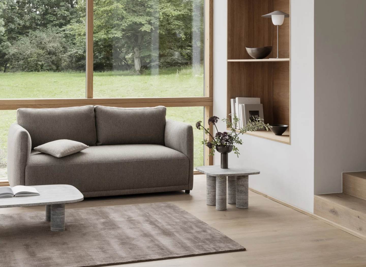 Blomus Volos Couchtisch aus Travertin im Wohnzimmer mit Sofa und Teppich.