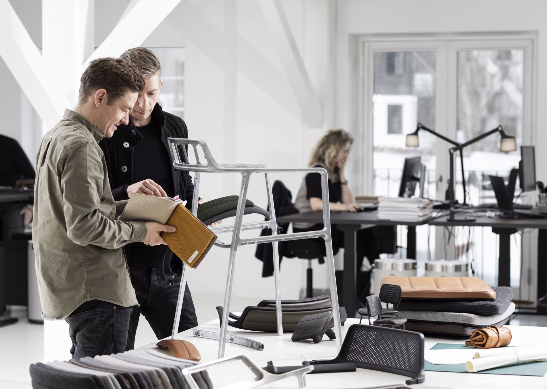 Vipp Stuhl sandfarbenes Anilinleder: Detailaufnahme von Stuhlkomponenten und Farbmustern im modernen Büro. Hochwertige Ledermöbel für stilvolles Wohnen.