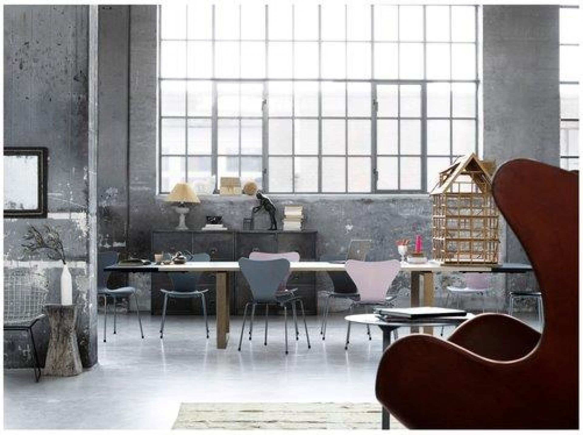 Heller Raum mit Essay Tisch von Fritz Hansen und Stühlen in verschiedenen Farben.