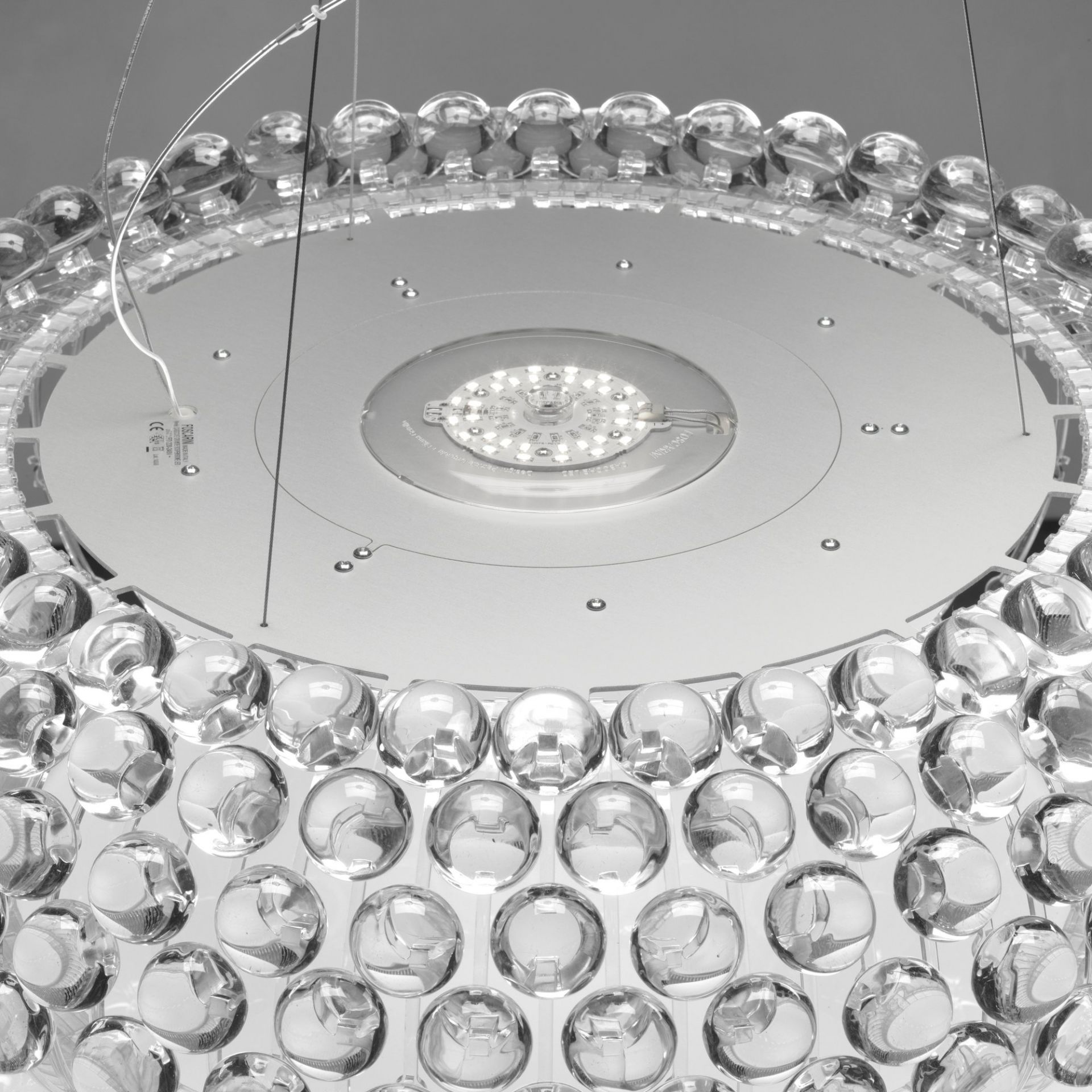 Detailaufnahme der Caboche Pendelleuchte von Foscarini mit transparenten Kugeln und LED-Licht.