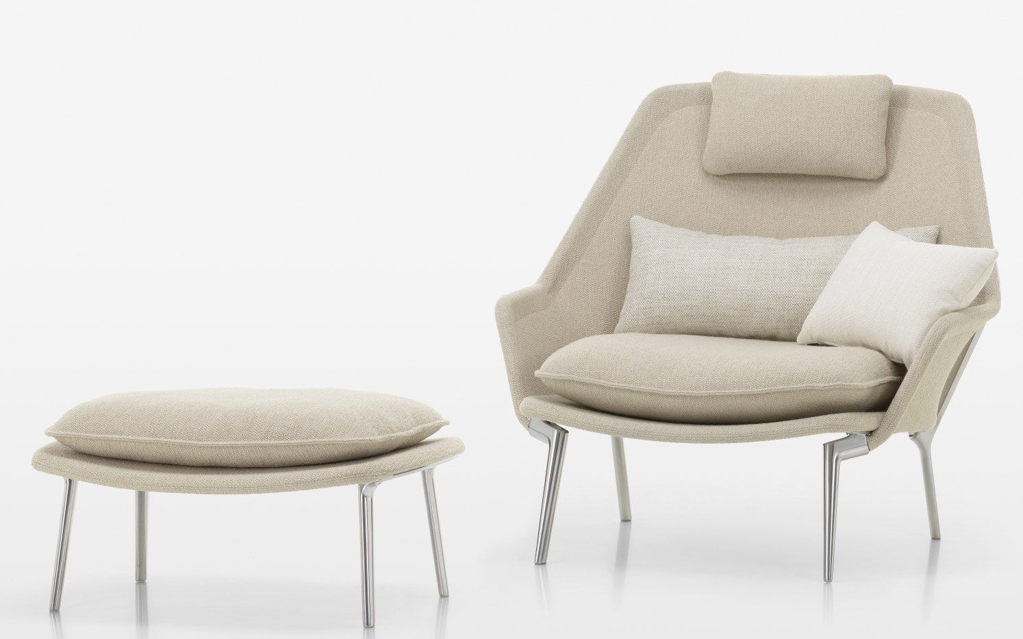 Vitra Slow Chair Sessel mit Ottoman in hellem Stoffbezug und Kissen auf weißem Hintergrund.