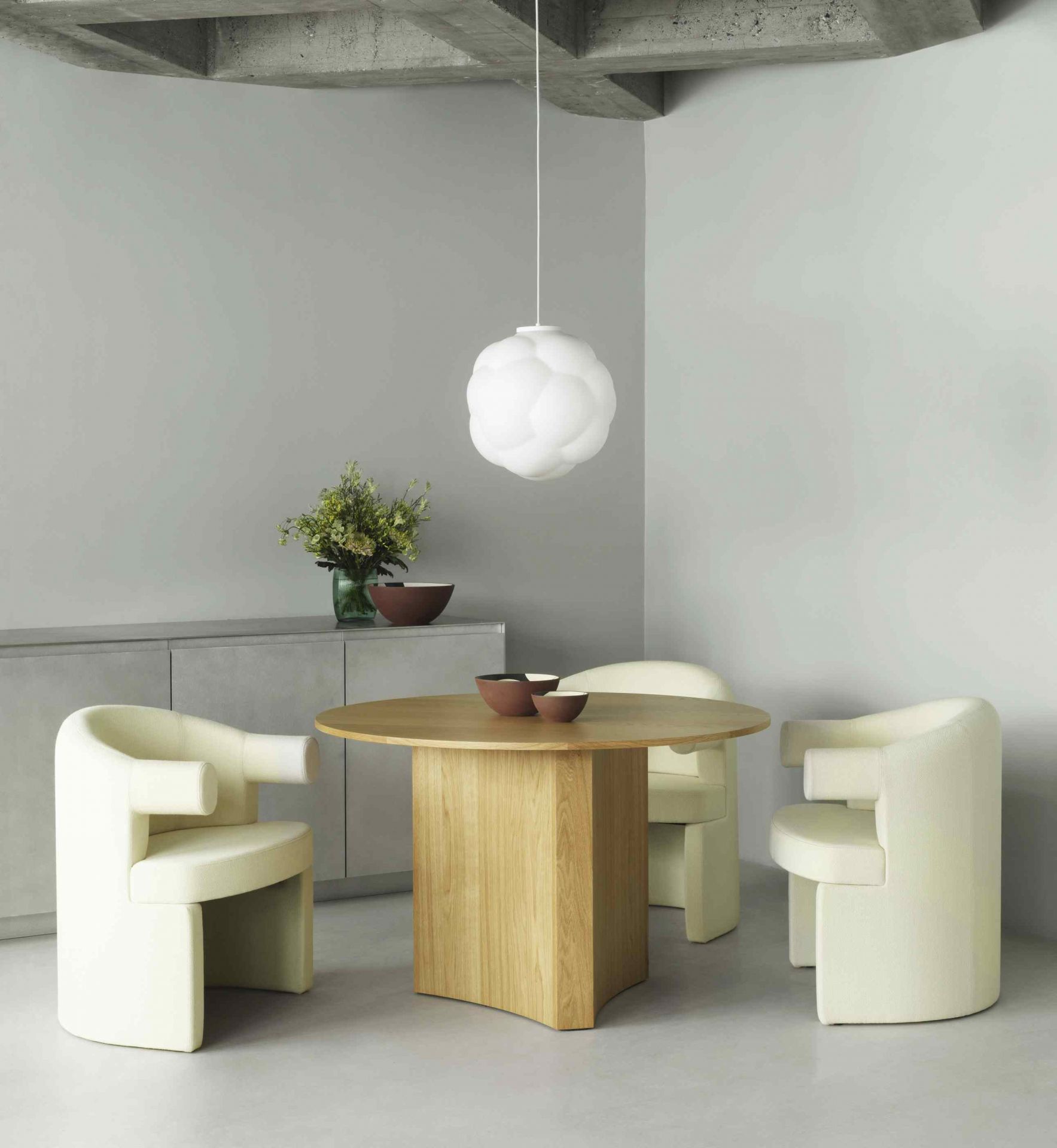 Weiße Bubba Pendelleuchte von Normann Copenhagen über Esstisch mit Stühlen. Moderne Innenraumbeleuchtung.