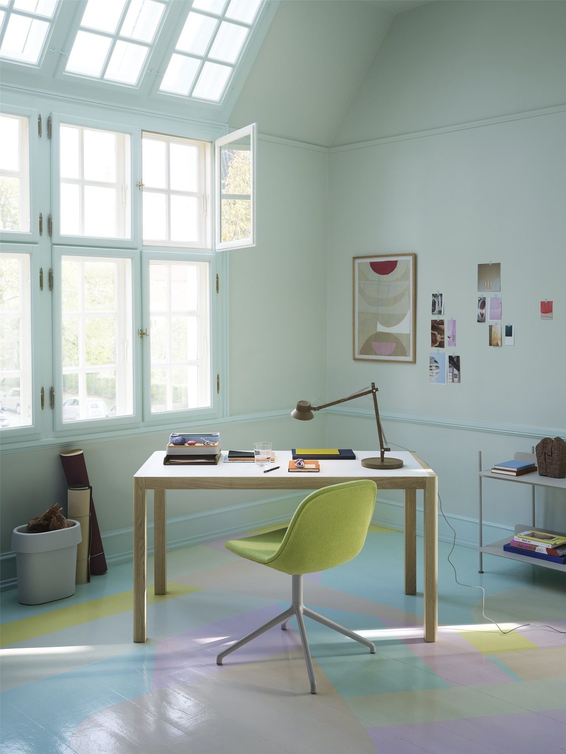 Schreibtisch mit Muuto Arrange Organizer, Stift, Lampe und grünem Stuhl in hellem Arbeitszimmer.