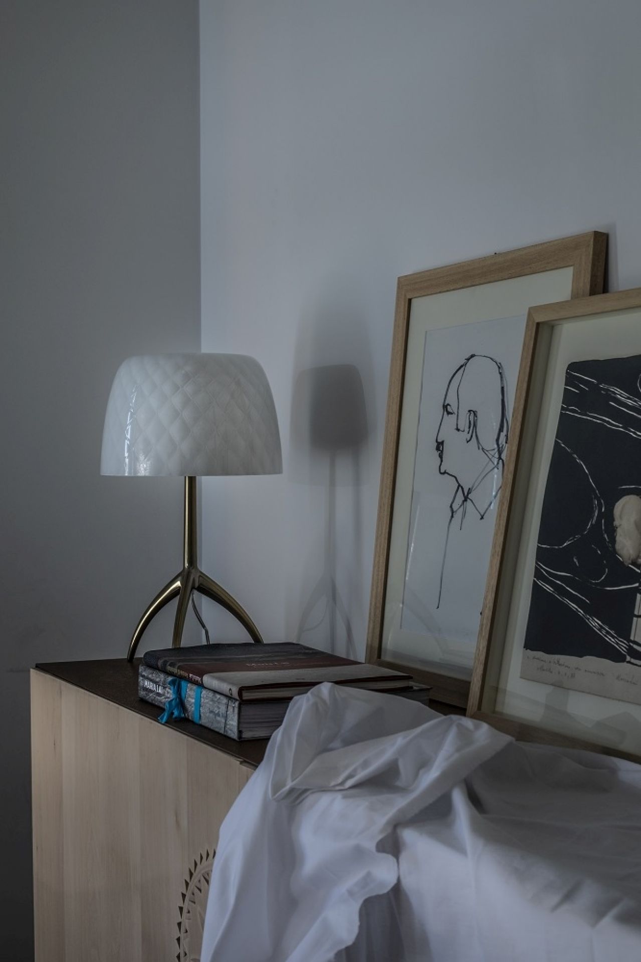 Nahaufnahme der Lumiere Tischleuchte von Foscarini mit weißem Schirm und goldenem Stativfuß.
