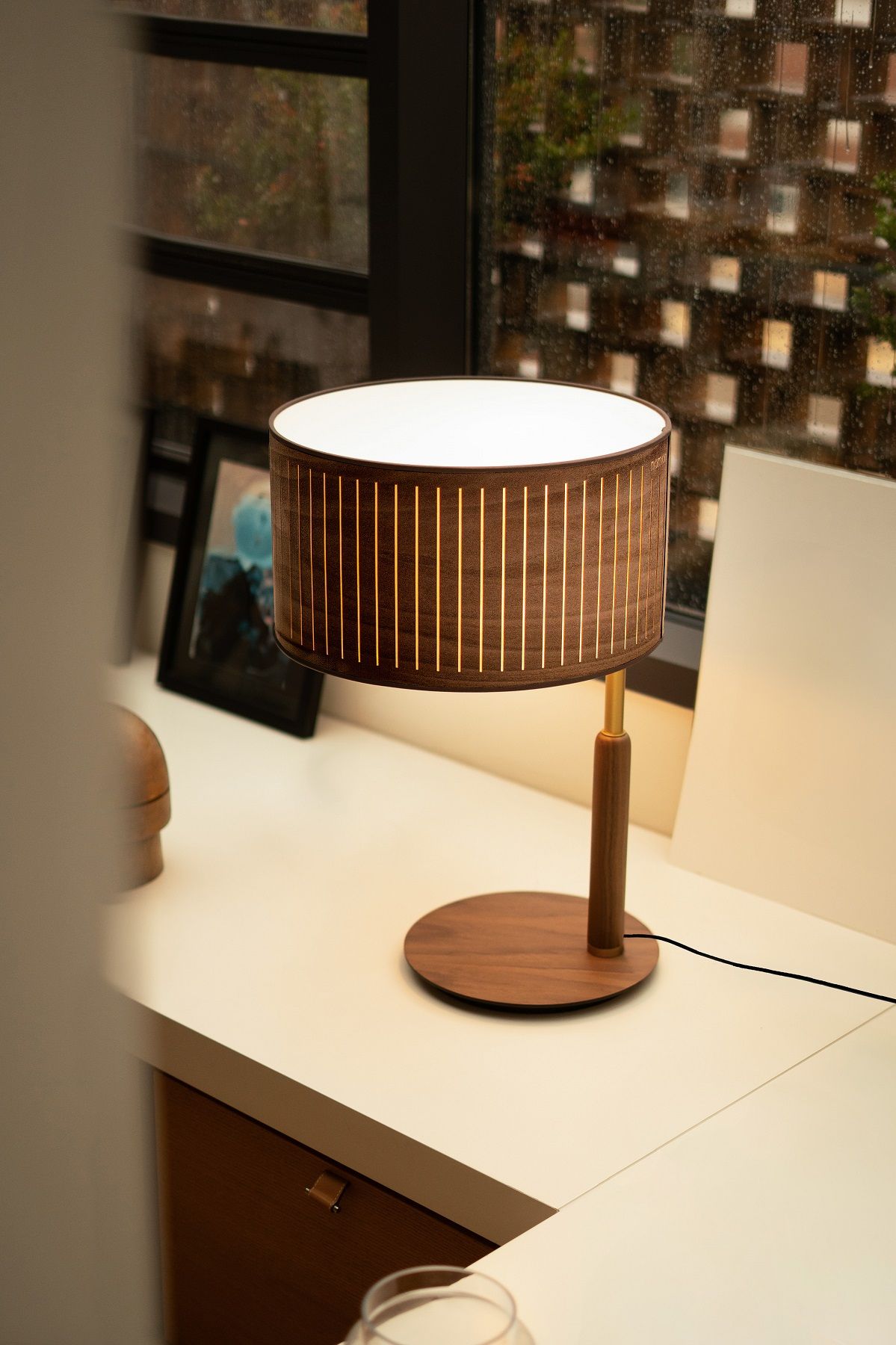 Elegante Autumn Table Lamp Tischleuchte von Nomon aus Holz und Stoff auf einem Tisch.