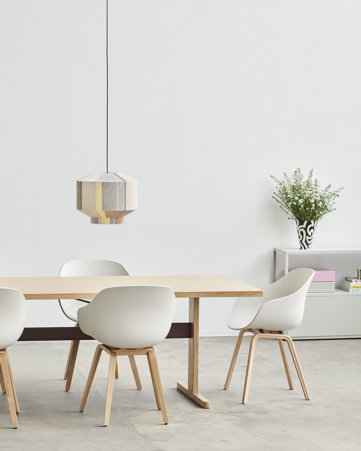Esszimmer mit Holztisch und weißen About a Chair AAC222 Stühlen von Hay mit Holzbeinen.