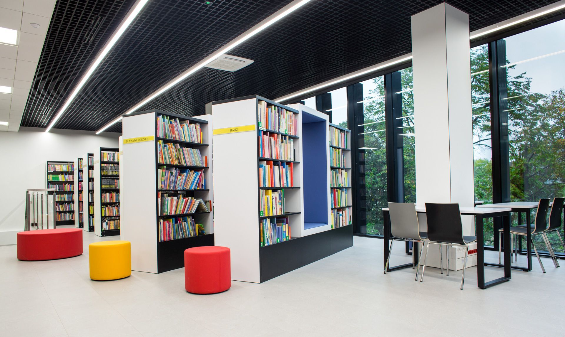 Rote und gelbe Bejot point POP R 450 Poufs als Sitzhocker auf Rollen in Bibliothek.