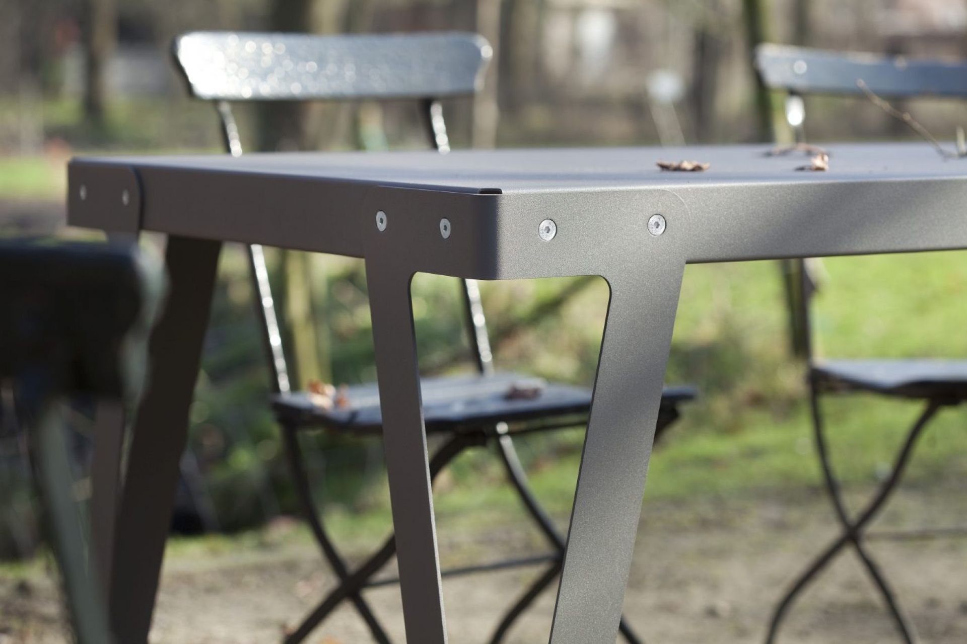 Detailaufnahme des Lloyd Outdoor Tischs von Functionals, ein grauer Gartentisch mit Stühlen.