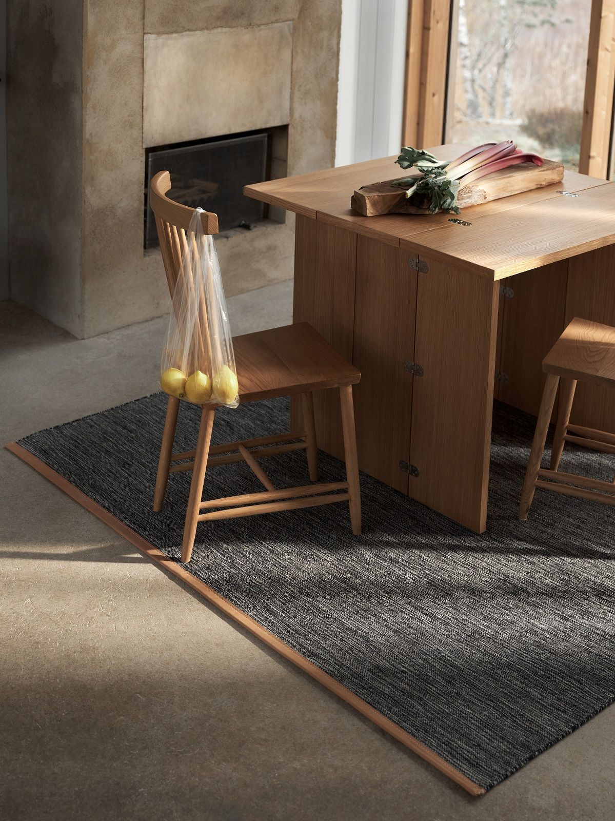 Detailaufnahme des Björk Teppichs von Design House Stockholm in einem Esszimmer mit Holzmöbeln.