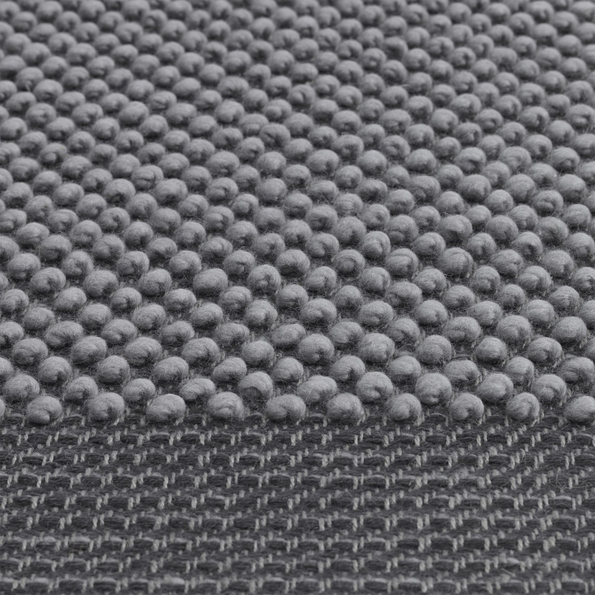 Detailaufnahme des grauen Muuto Pebble Rug Teppichs mit auffälliger Noppenstruktur und gewebtem Untergrund.