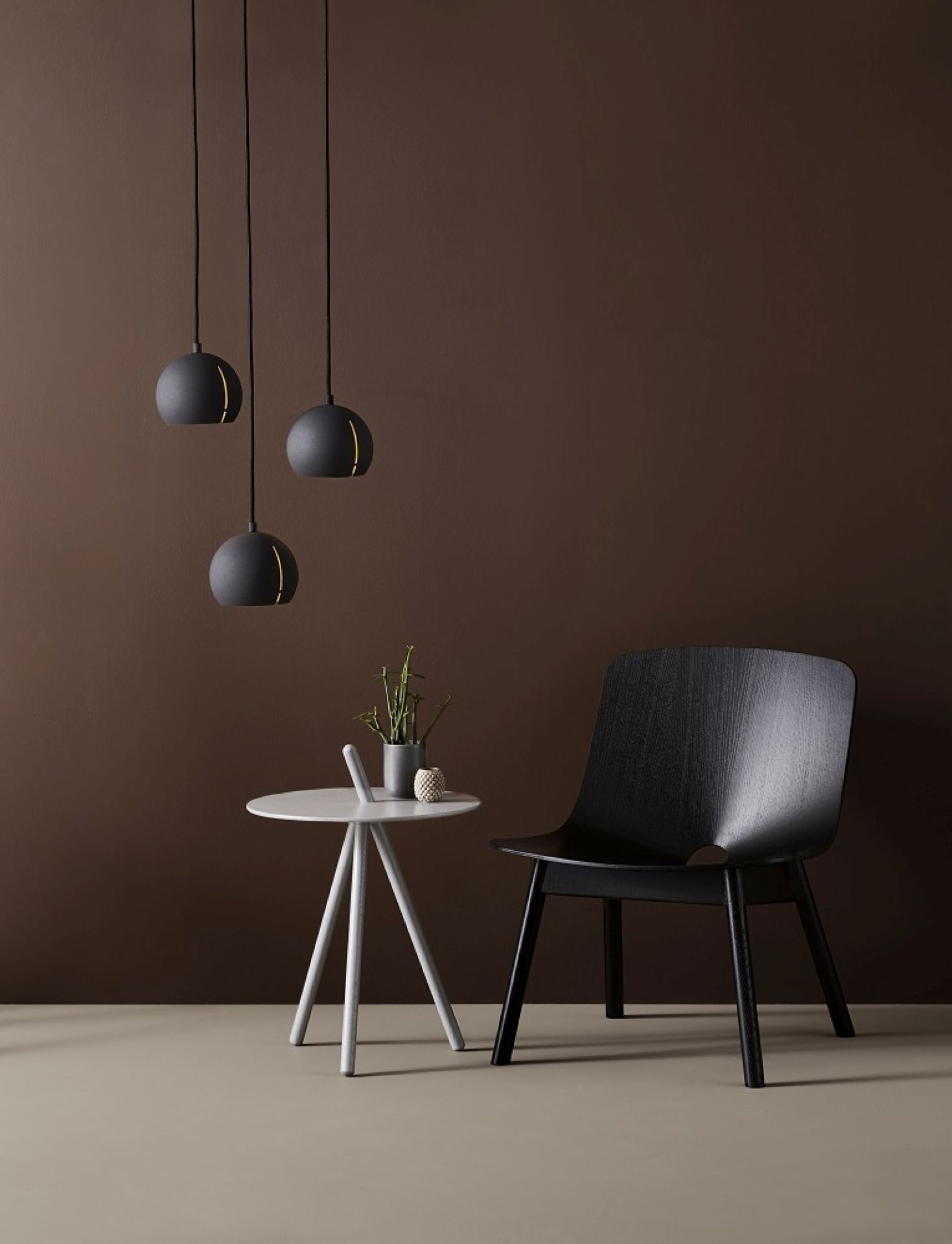 Drei schwarze Gap Pendelleuchten von Woud über einem Tisch und Stuhl, modernes Design.