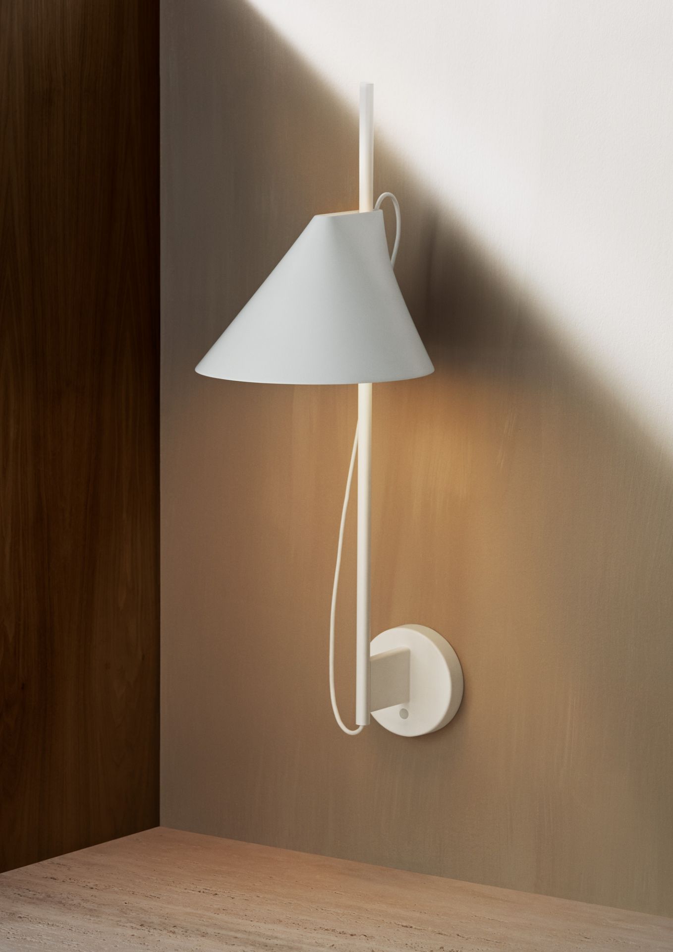 Nahaufnahme der weißen Yuh LED Wandleuchte von Louis Poulsen, die warmes Licht an einer Wand ausstrahlt.