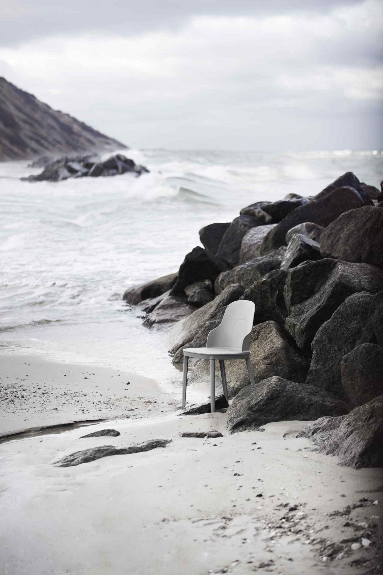 Allez Chair von Normann Copenhagen, grauer Design Stuhl am Strand zwischen Felsen.