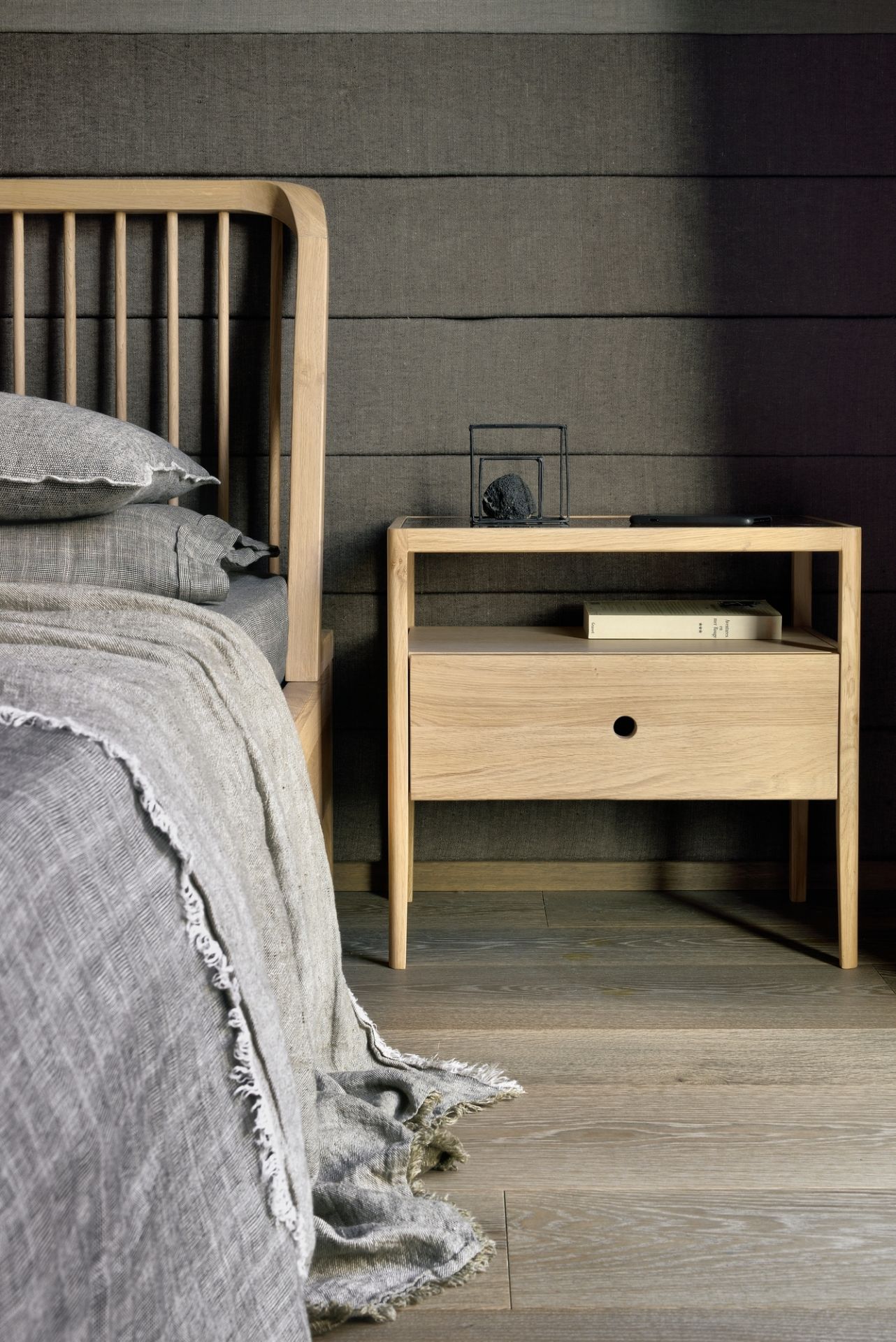 Detailaufnahme des Ethnicraft Spindle Bettes aus Eiche mit passendem Nachttisch im Schlafzimmer.