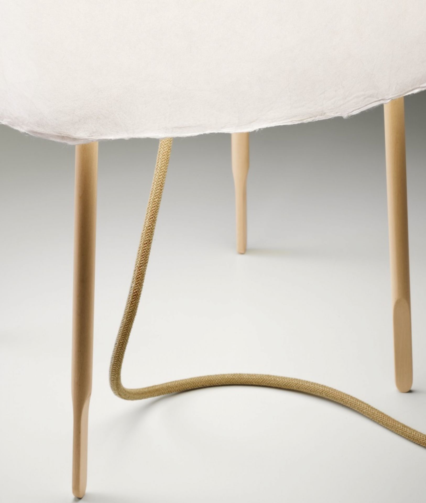 Detailaufnahme der Kurage Tischleuchte von Foscarini mit hellem Schirm und Holzbeinen.