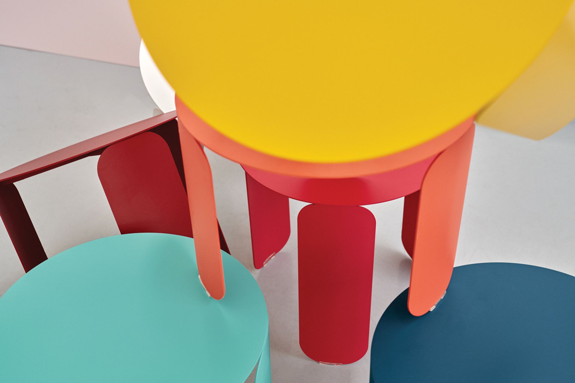 Detailaufnahme von mehreren farbenfrohen Fermob Beistelltischen der Serie Bebop Outdoor Side Table in Gelb, Rot, Türkis und Blau.