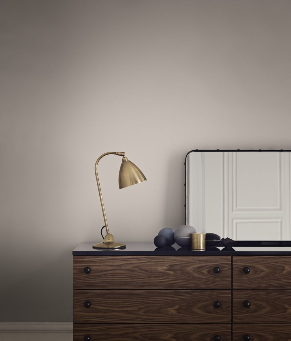 Gubi Sideboard 62 aus Holz mit sechs Schubladen, Lampe und Spiegel im Schlafzimmer.