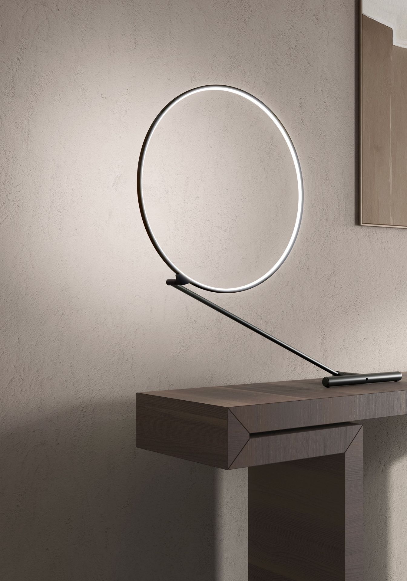 Poise Tischleuchte von Kdln: Moderne LED-Tischlampe mit kreisförmigem Leuchtkörper auf einem dunklen Holztisch.
