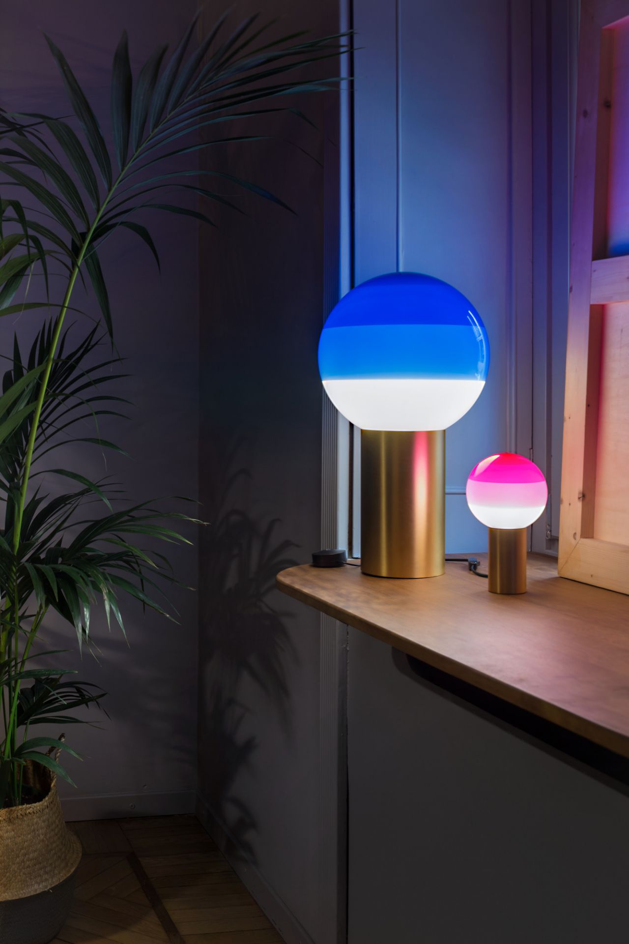 Dipping Light Tischleuchte von Marset in Bernstein und Messing, stimmungsvolle Beleuchtung im Raum.