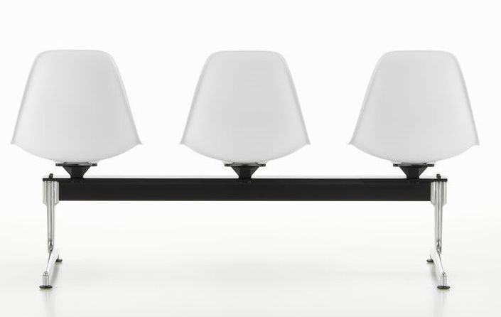 Eames Side Chair RE auf Traverse Vitra, Wartebank mit drei weißen Kunststoffschalen und schwarzem Untergestell.